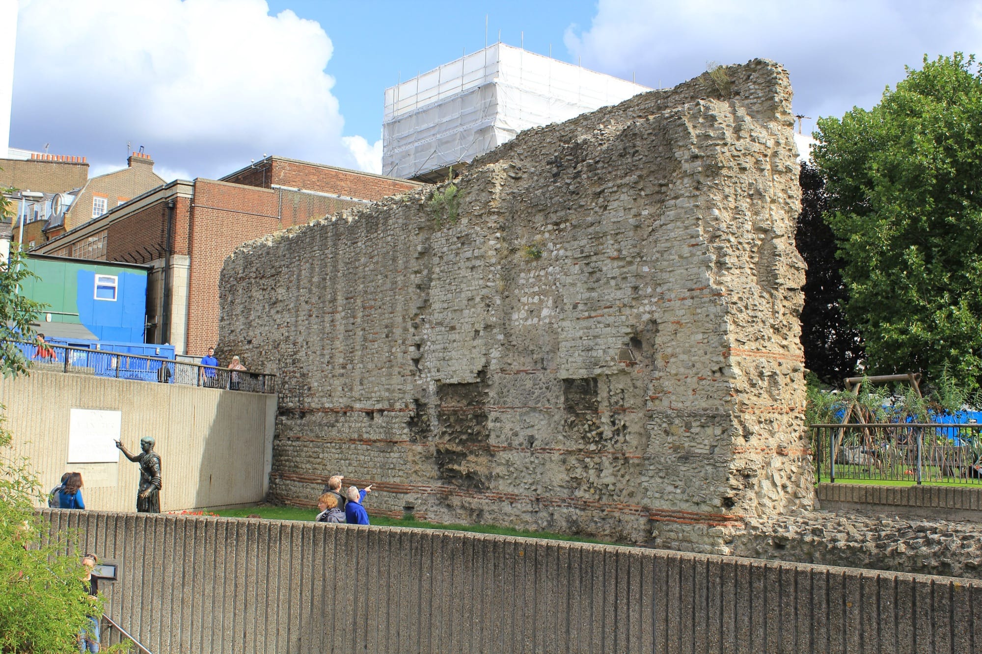 Vestiges du mur romain de Londres à Tower Hill, avec la statue de l'empereur Trajan