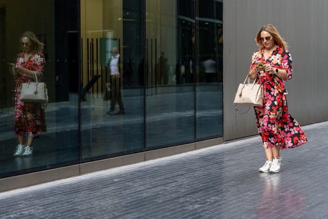 Entrepreneuse marchant devant une façade vitrée à Londres
