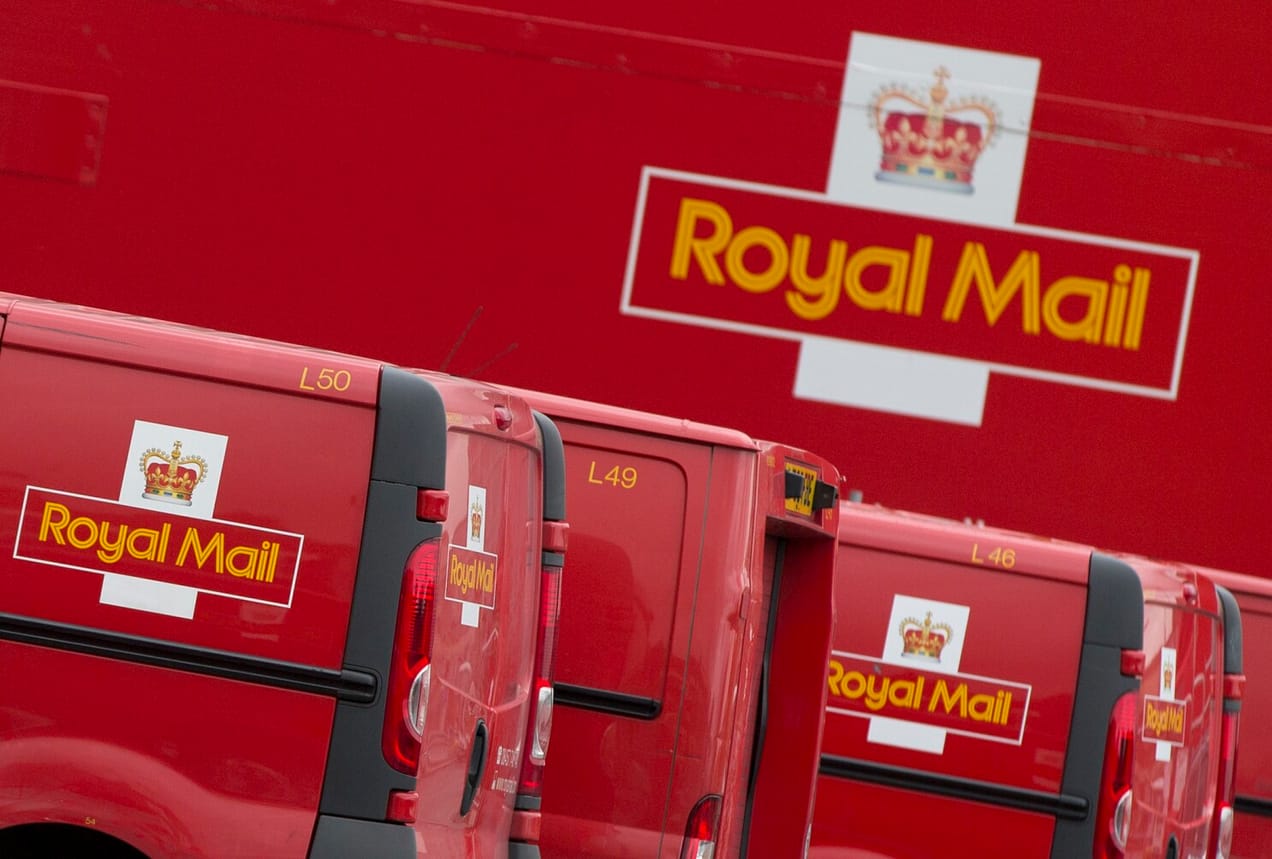 Royal Mail logo en fond d'image avec les camions de livraison royal mail devant.
