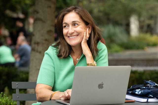 Entrepreneuse souriante devant son ordinateur portable, photographiée par Albane Brand Photography